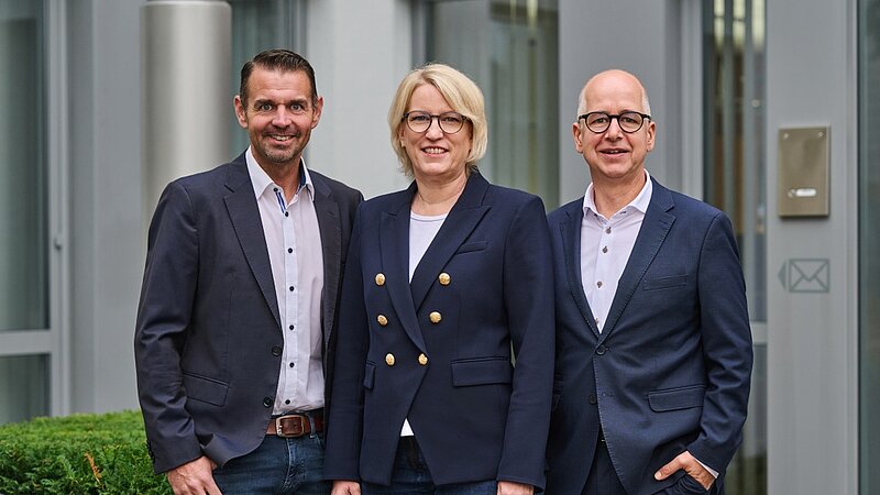 Die Geschäftsleitung vor dem Firmengebäude