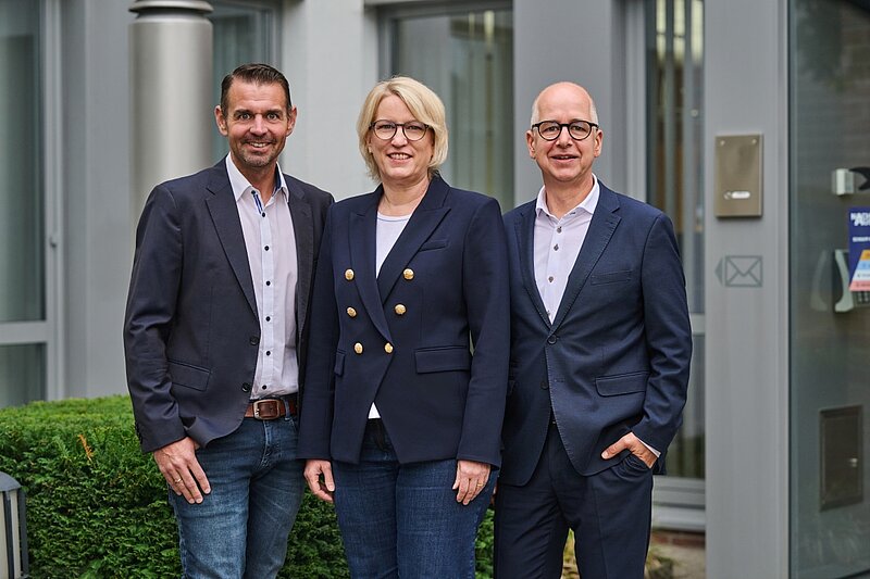 Die Geschäftsleitung vor dem Firmengebäude