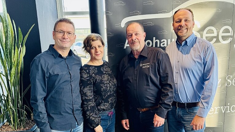 Vier Personen in einem Autohaus