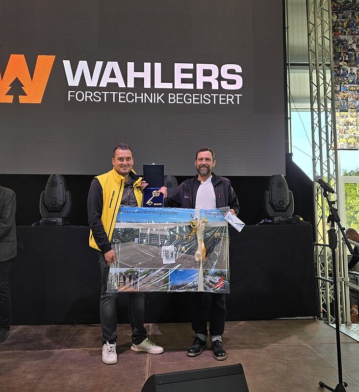 zwei Personen auf einer Bühne während der Eröffnungsfeier bei Firma Wahlers