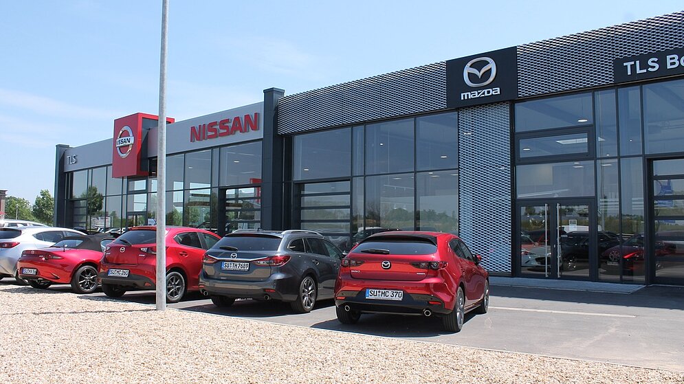 Frontansicht des Mehrmarken-Autohauses für Nissan und Mazda mit Außenausstellung