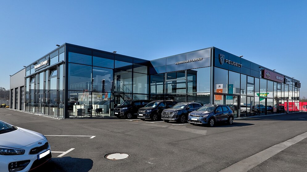 Modernes Mehrmarken-Autohaus für Kia und Abarth mit großflächiger Glasfront