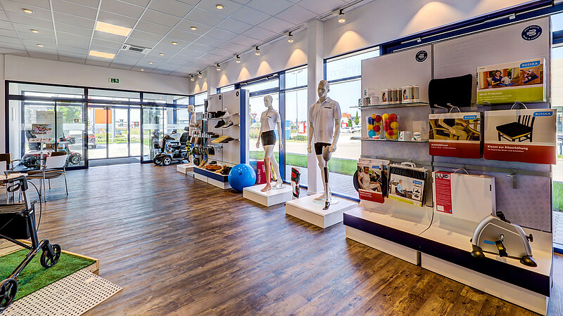 Innenansicht eines Sanitätshaus mit Verkaufsregalen, Schaufensterpuppen und einem großen Fensterbereich