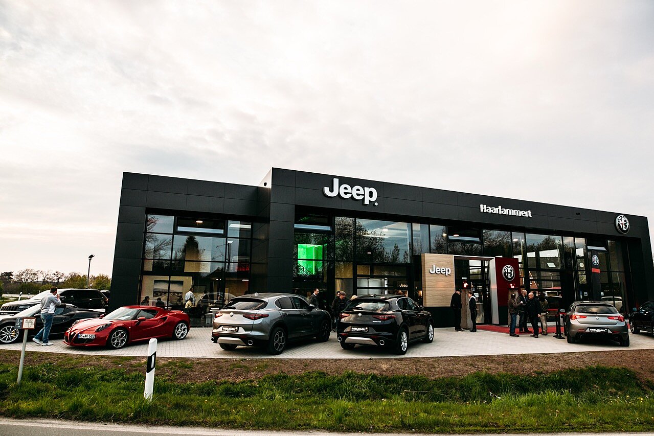 Frontansicht des Jeep Autohauses mit schwarzer Fassade und Glasfront von der Straße