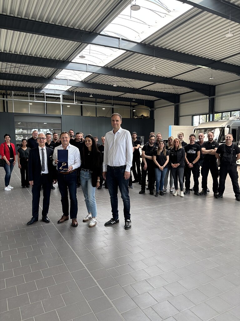 Gruppe Menschen in einer Karosseriehalle