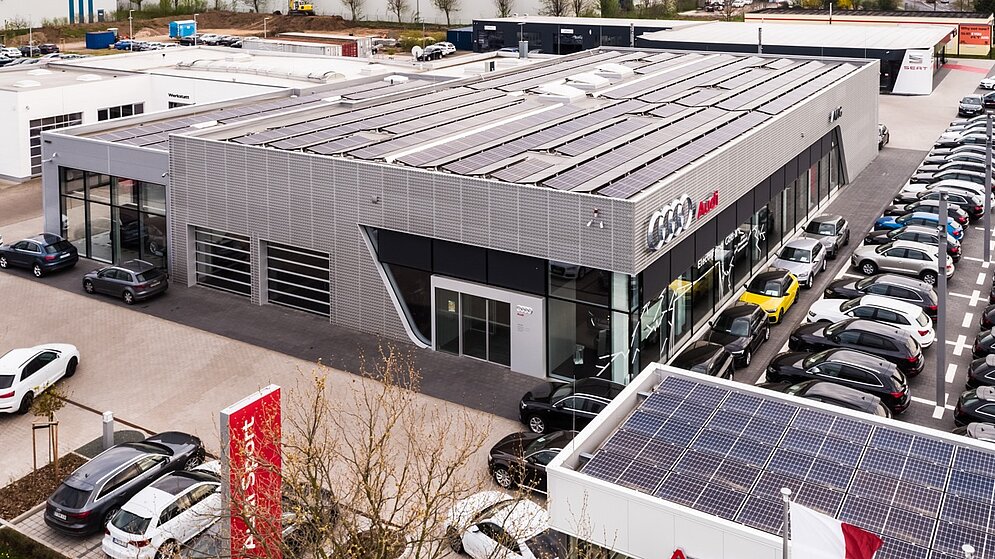 Luftaufnahme des Autohauses zeigt Dachflächen mit Photovoltaikanlage und Gebäudestruktur