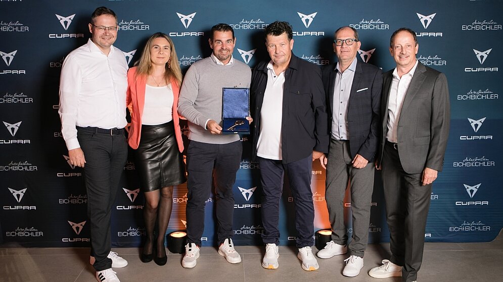 Sechs Personen bei der Eröffnung des neuen Autohauses mit goldenem Schlüssel