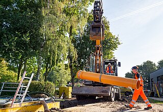 Baggerfahrer und Azubi auf einer Tiefbaubaustelle