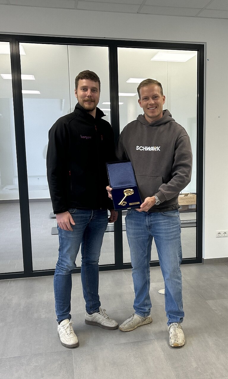 Zwei Personen mit goldenem Schlüssel in der Hand