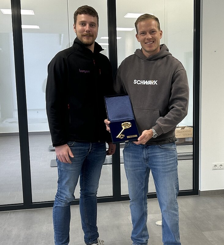 Zwei Personen mit goldenem Schlüssel in der Hand