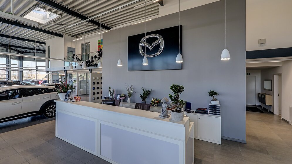 Empfangsbereich mit moderner Theke und Mazda-Branding an der Rückwand