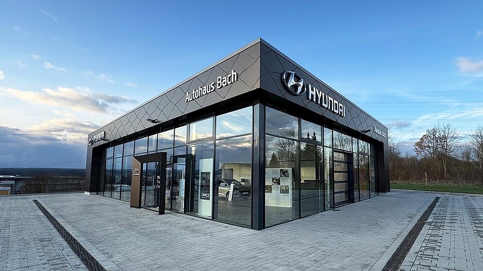 Moderne Glasarchitektur des Autohaus Bach mit Hyundai-Branding im Eingangsbereich