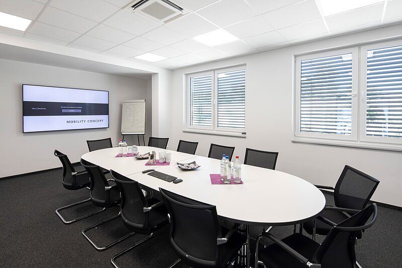 Besprechungsraum mit langem Tisch und Medientechnik im Verwaltungsbereich