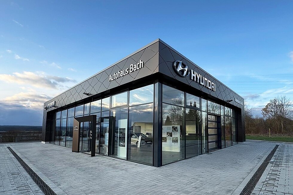 Moderne Glasarchitektur des Autohaus Bach mit Hyundai-Branding im Eingangsbereich