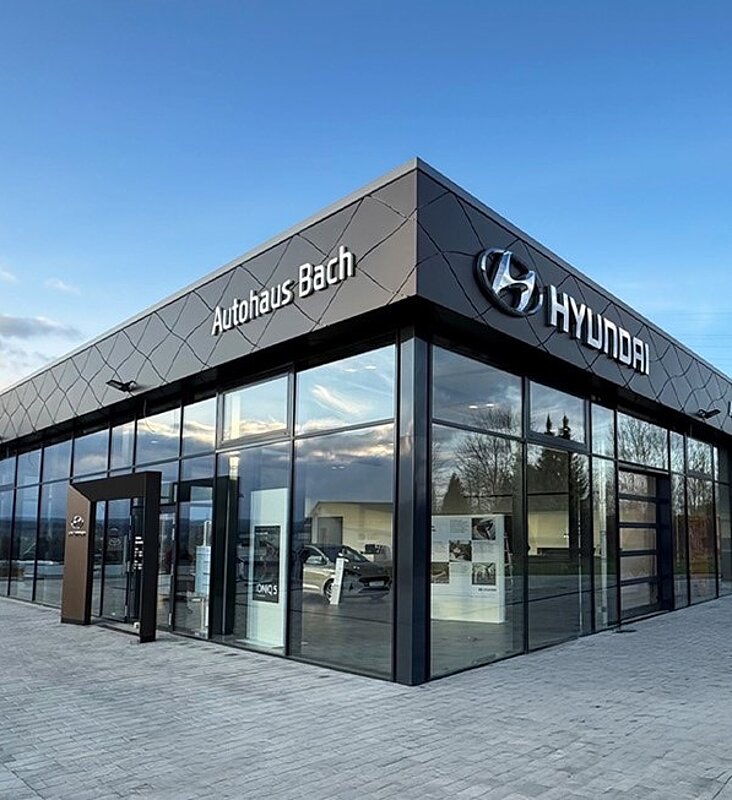 Moderne Glasarchitektur des Autohaus Bach mit Hyundai-Branding im Eingangsbereich