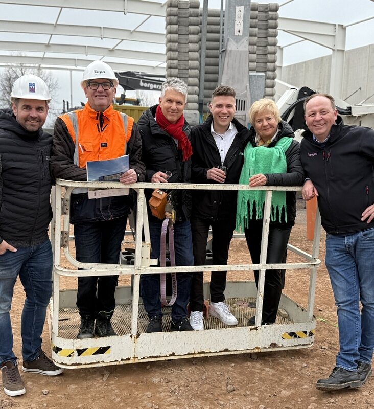 Sechs Personen beim Richtfest auf einer Hebebühne