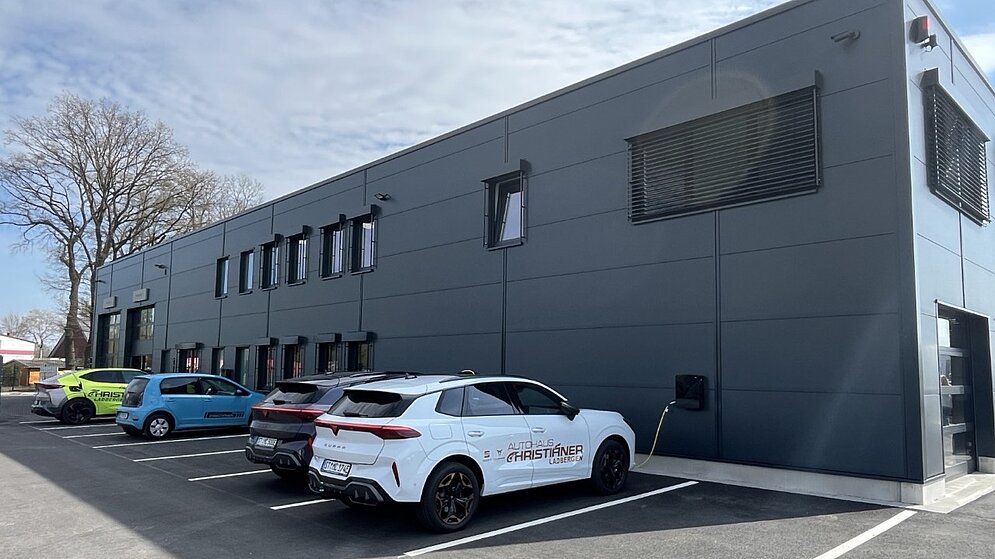 Rückwärtige Gebäudeseite mit grauer Industriefassade und Mitarbeiterparkplätzen
