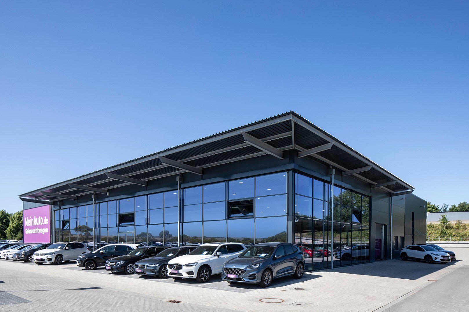 Moderne Glasfassade des Autohauses mit markanter Stahl-Dachkonstruktion