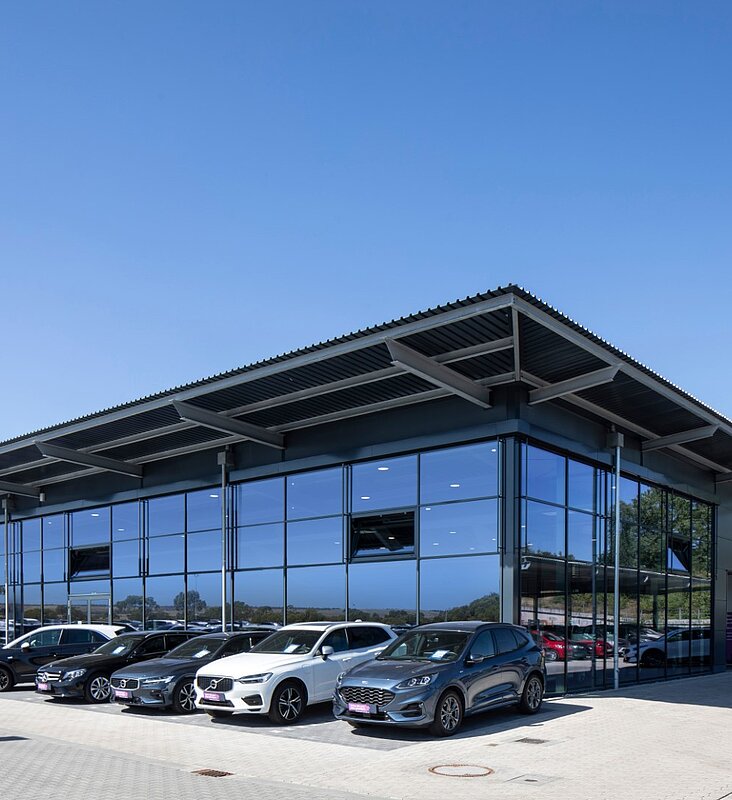 Moderne Glasfassade des Autohauses mit markanter Stahl-Dachkonstruktion