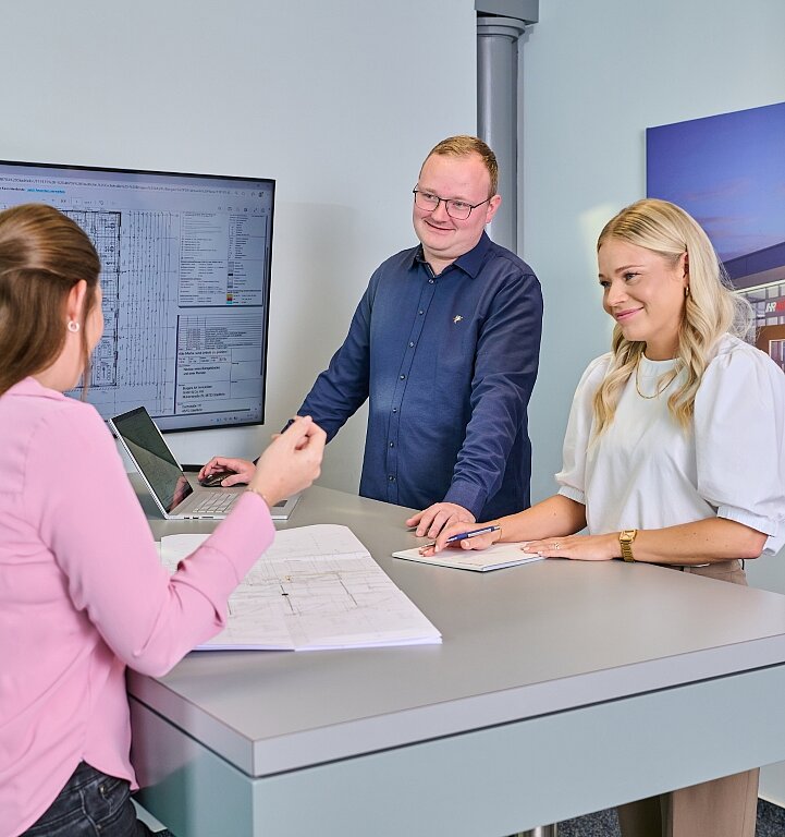 Vier Mitarbeiter der Borgers GmbH unterhalten sich. Es ist ein Bildschirm mit Plänen im Hintergrund zu sehen.