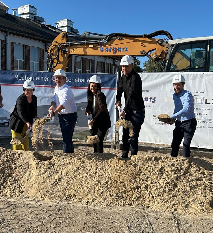 Sechs Personen beim Spatenstich der Firma LZD Lackzentrum Dormagen mit Spaten in der Hand und Bauhelmen