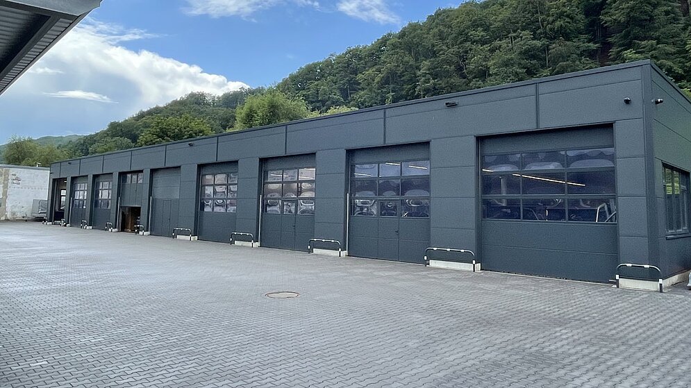 Außenansicht des Werkstatttrakts mit mehreren grauen Sektionaltoren