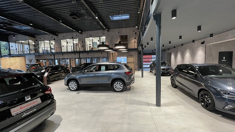 Innenraum des Autohauses mit Fahrzeugen und industriellem Decken-Design