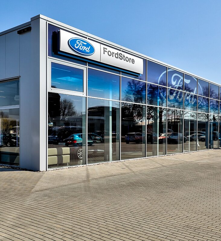 Außenansicht des Ford Stores mit moderner Glasarchitektur und gepflastertem Vorplatz