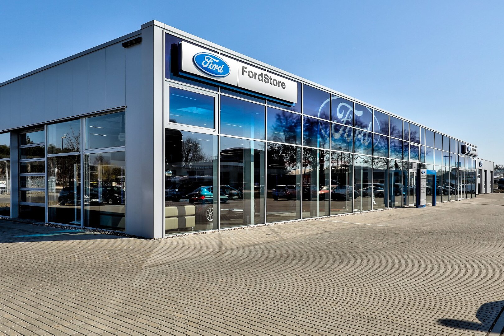 Außenansicht des Ford Stores mit moderner Glasarchitektur und gepflastertem Vorplatz
