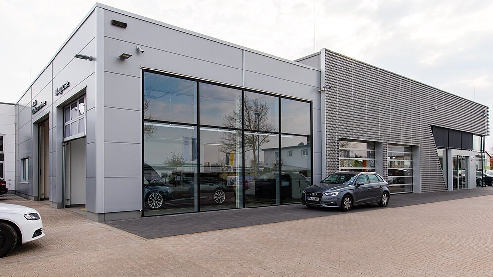 Außenansicht der modernen Gebäudefassade und Werkstatttore des schlüsselfertigen Autohauses