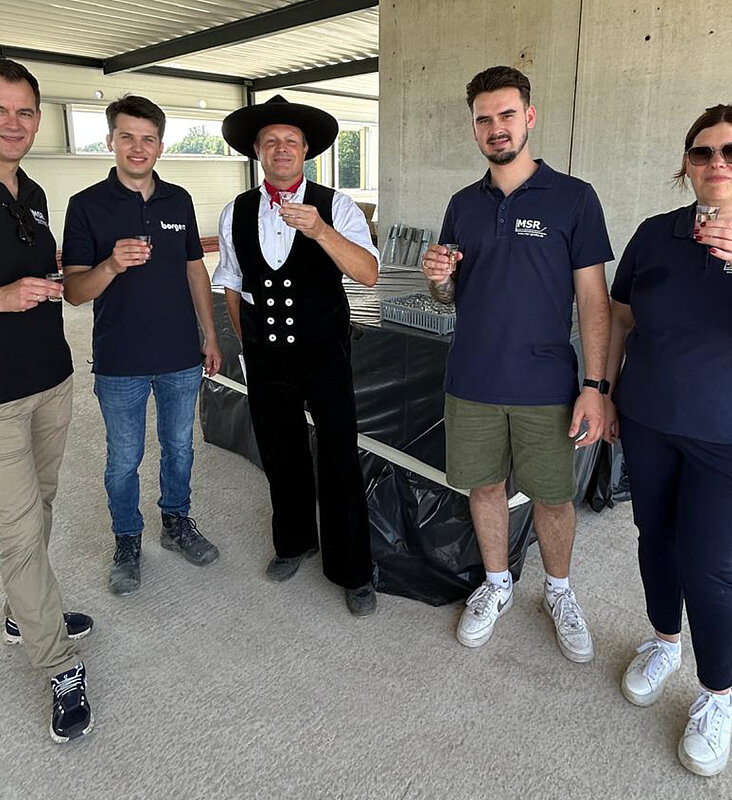 Richtfest_fünf Personen im Rohbau