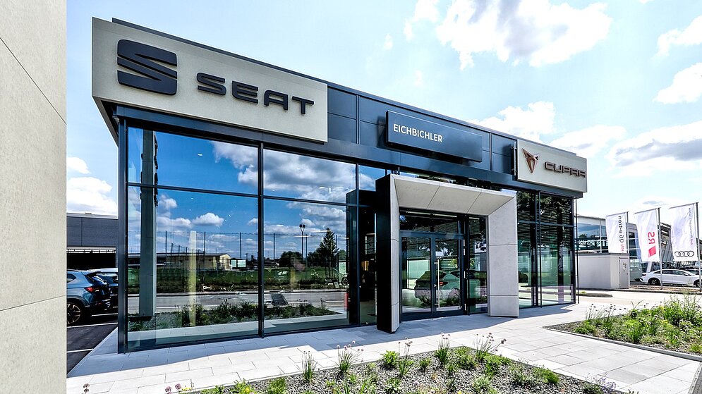 Eingangsportal des Autohauses mit markanter Seat-Signalisation und moderner Glasarchitektur
