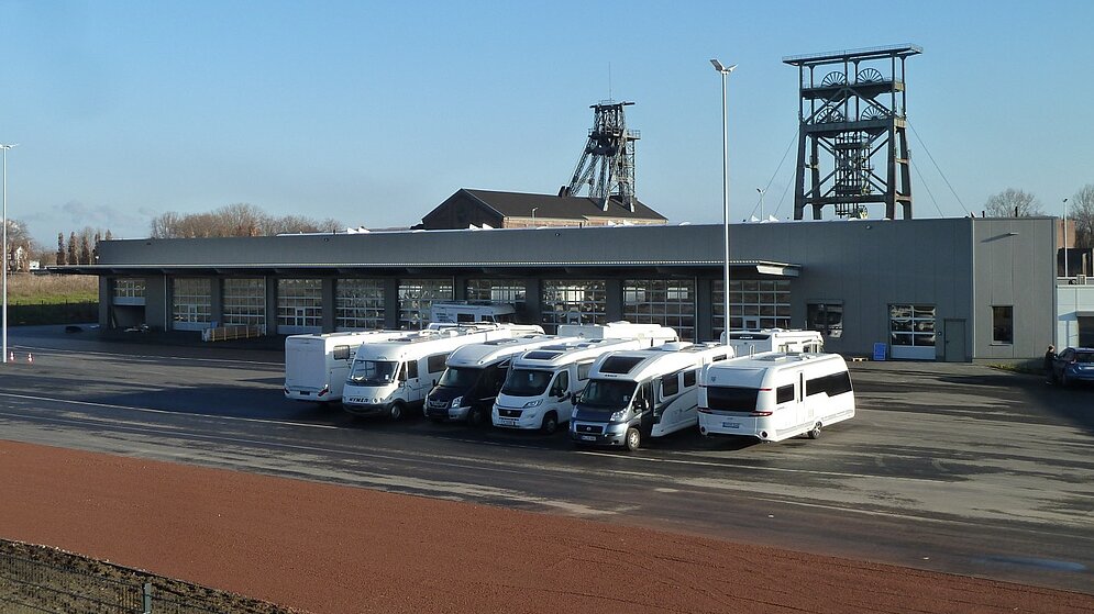 Außenansicht einer Verkaufs- und Wartungshalle für Wohnmobile mit mehreren Fahrzeugen auf dem Gelände