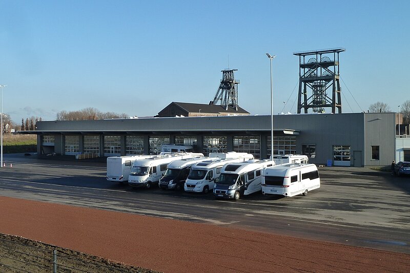 Außenansicht einer Verkaufs- und Wartungshalle für Wohnmobile mit mehreren Fahrzeugen auf dem Gelände