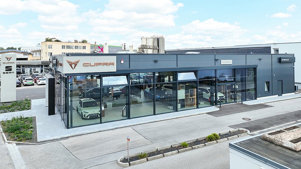 Erhöhte Außenansicht des Autohauses zeigt Gebäudestruktur mit Flachdach und Glasfront