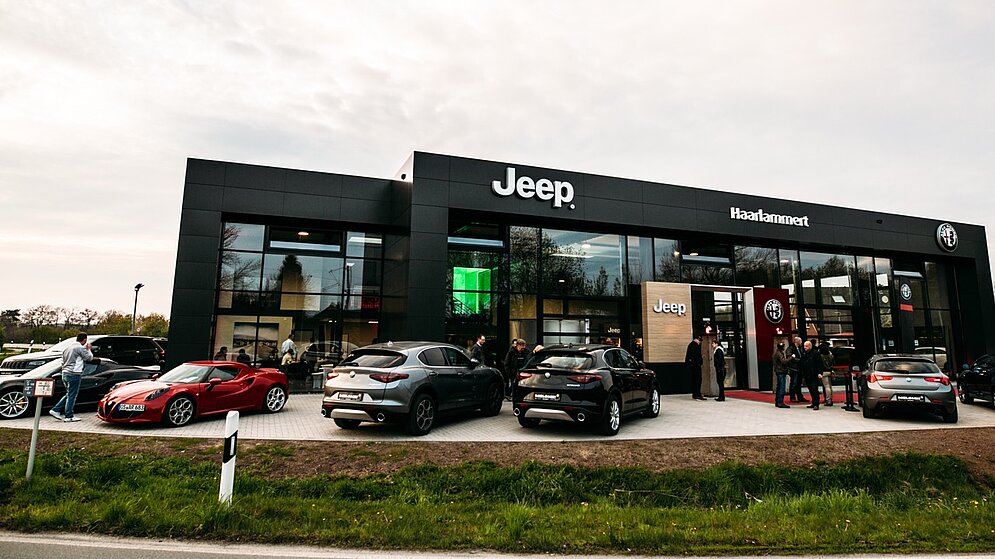 Frontansicht des Jeep Autohauses mit schwarzer Fassade und Glasfront von der Straße