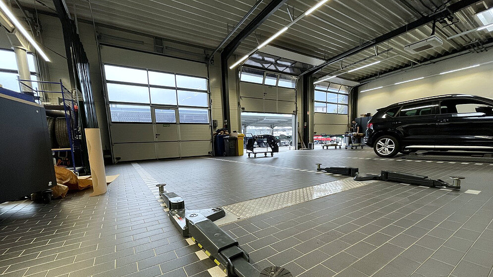 Blick in die Kfz-Werkstatt mit Hebebühnen und funktionalem Fliesenboden