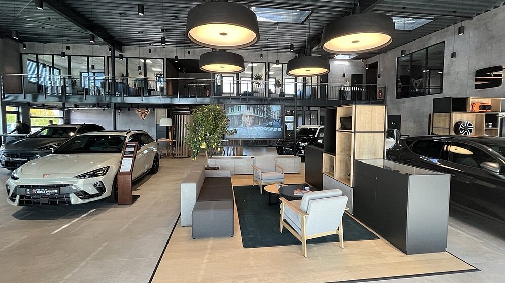 Wartebereich im Autohaus mit hochwertigem Mobiliar, Teppich und Blick auf den Empfang