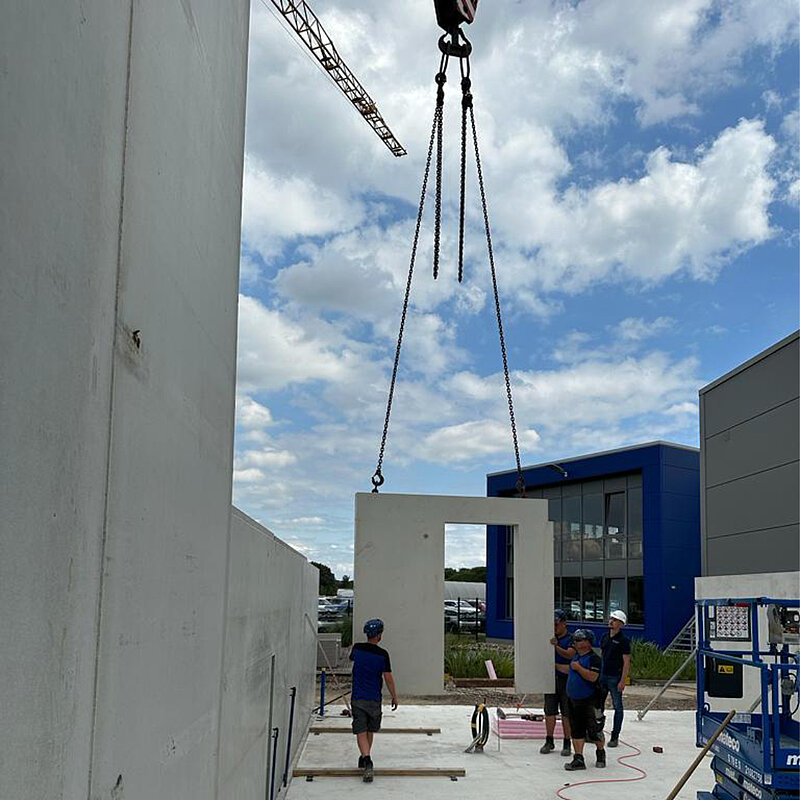 Bauarbeiter auf einer Baustelle mit einem Betonfertigteil