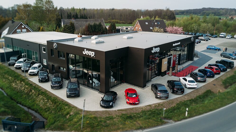 Luftbild der schlüsselfertigen Gewerbeimmobilie für Jeep mit Außenanlagen und Parkplätzen