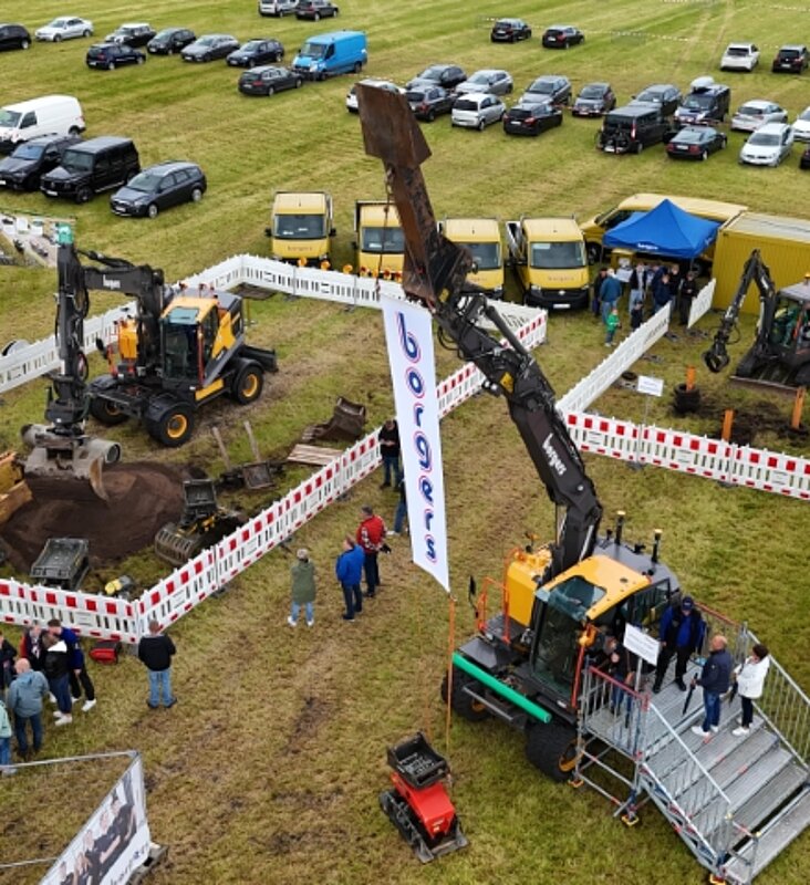 Bagger umgeben von einer Absperrung am Stand der Firma Borgers auf einer großen Rasenfläche