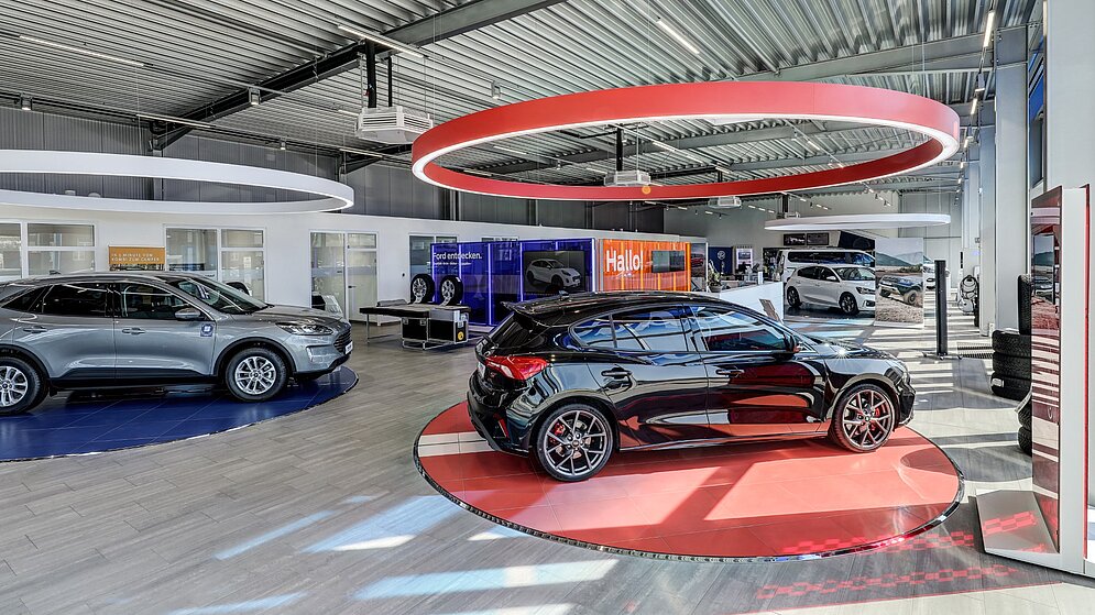 Showroom mit Highlight-Präsentationsfläche und runder Lichtinstallation an der Decke