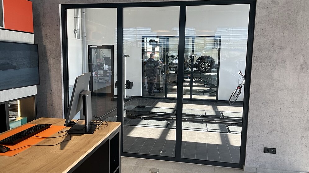 Innenraum mit Verglasung im Industrial-Style und Blick in den Servicebereich