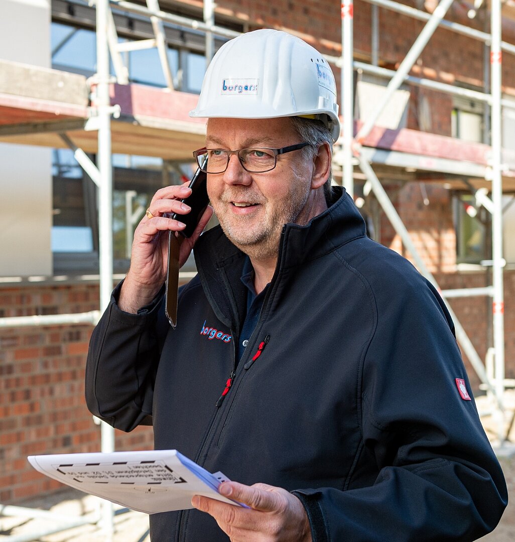 Bauleiter telefoniert auf einer Baustelle