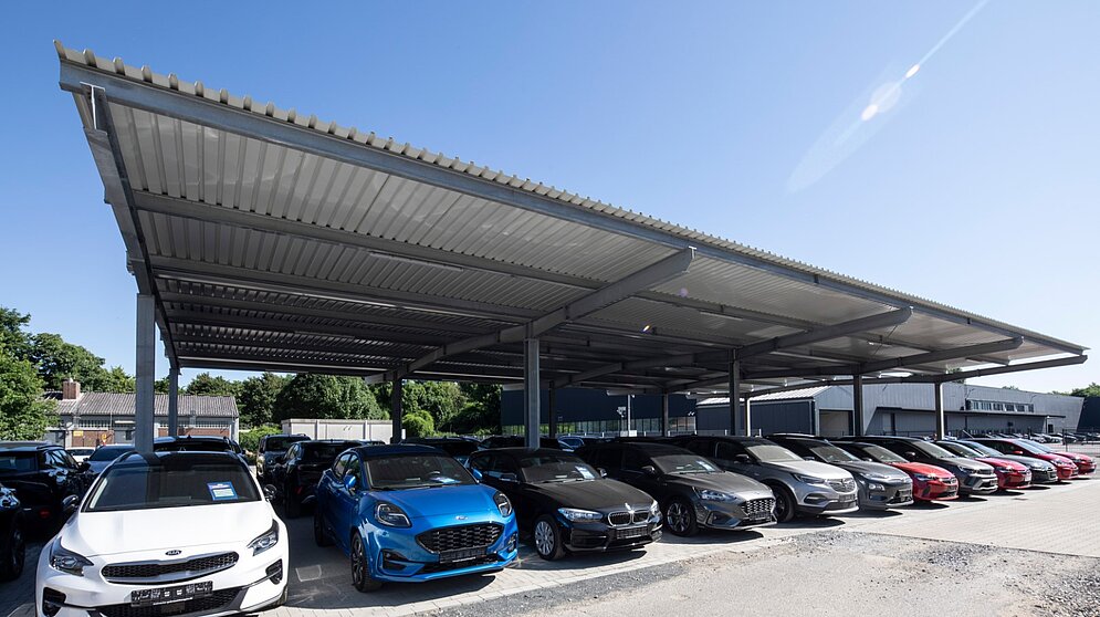 Großflächige Stahl-Überdachung für Fahrzeugstellplätze im Außenbereich des Autohauses