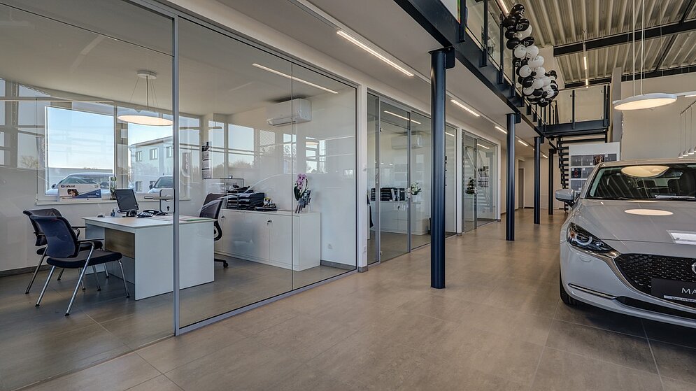 Innenraum mit verglasten Büros und Beratungsplätzen im hellen Showroom