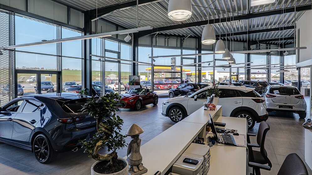 Blick von oben auf die Verkaufsfläche und Beratungszonen vor der Glasfassade