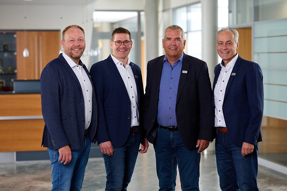 Vier Vertriebsmitarbeiter im Firmengebäude