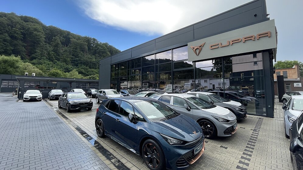 Eingangsportal des Autohauses mit Cupra-Branding und moderner Glasarchitektur