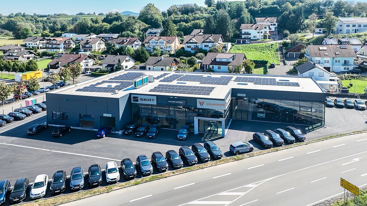  Luftbild eines modernen Autohauses mit Verkaufs- und Werkstattbereich und großem Kundenparkplatz